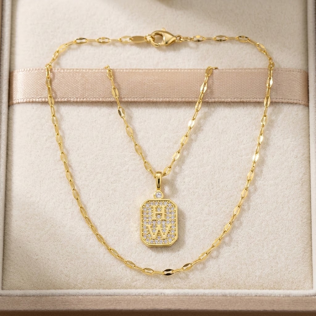 Gold-tone necklace in gift box, square W crystal tag charm on linked chain