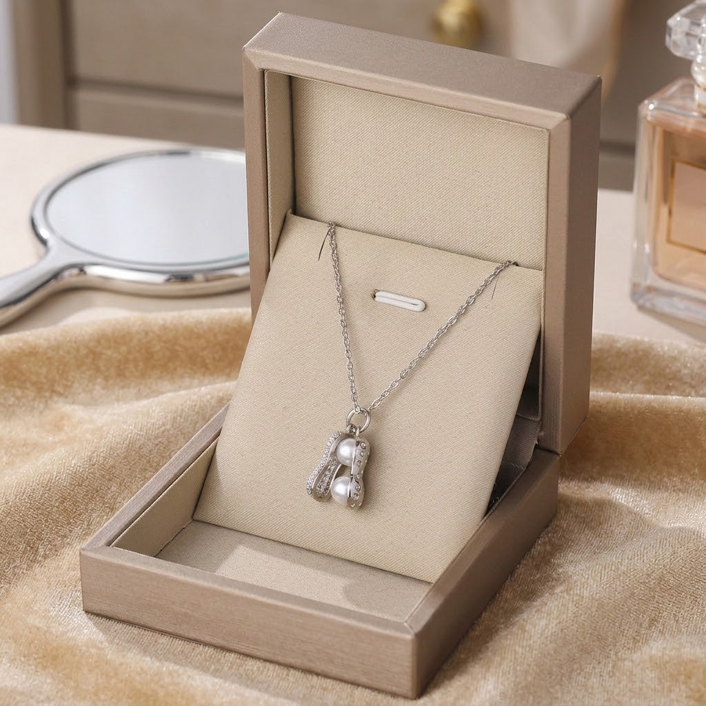 Silver-tone peanut-shaped charm necklace with white pearl beads and crystal accents