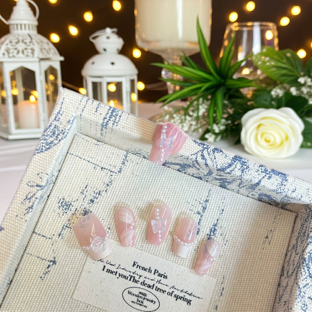 False nail tips set in blue patterned package with pink rhinestone bow designs