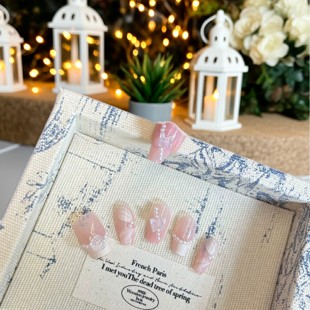Blue patterned false nail tips box with window showing pink glitter and gem nail art