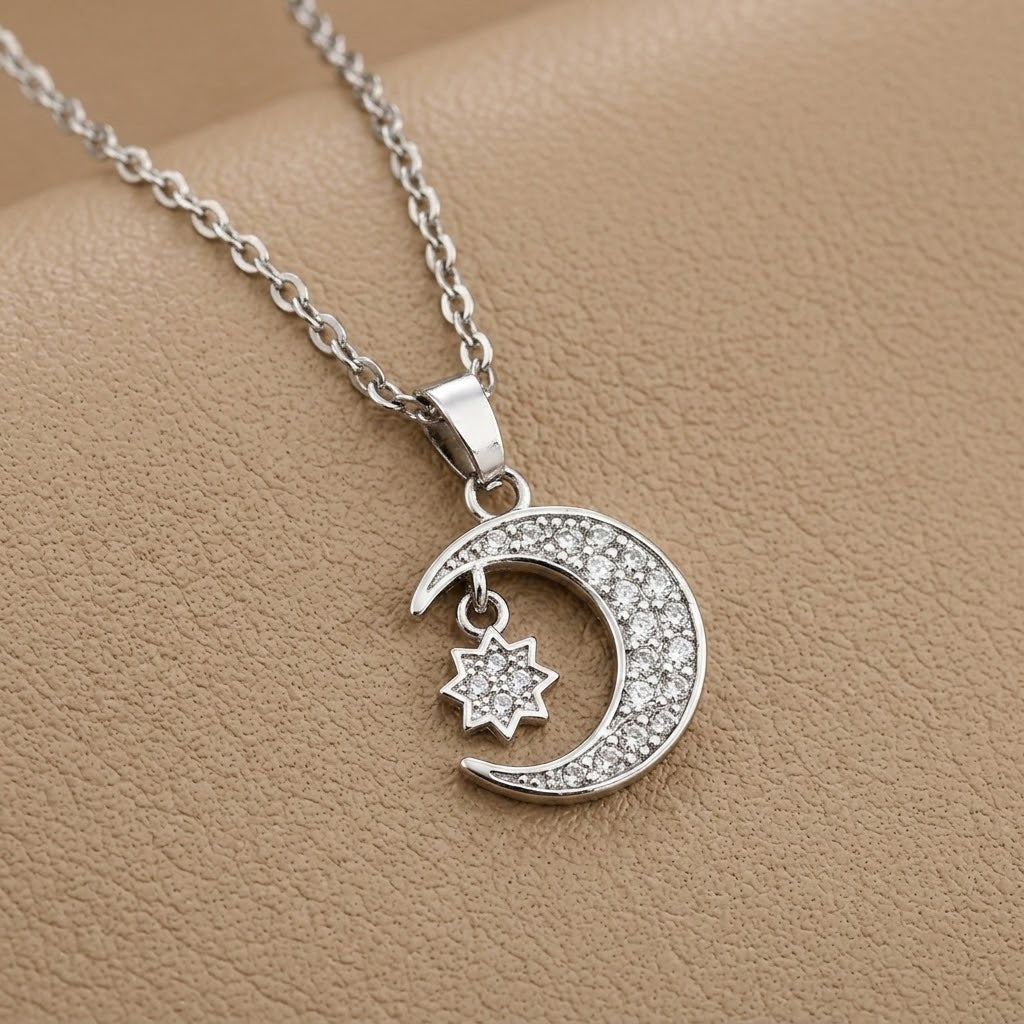 Crescent moon and star charm necklace with silver-tone chain and crystal pendant