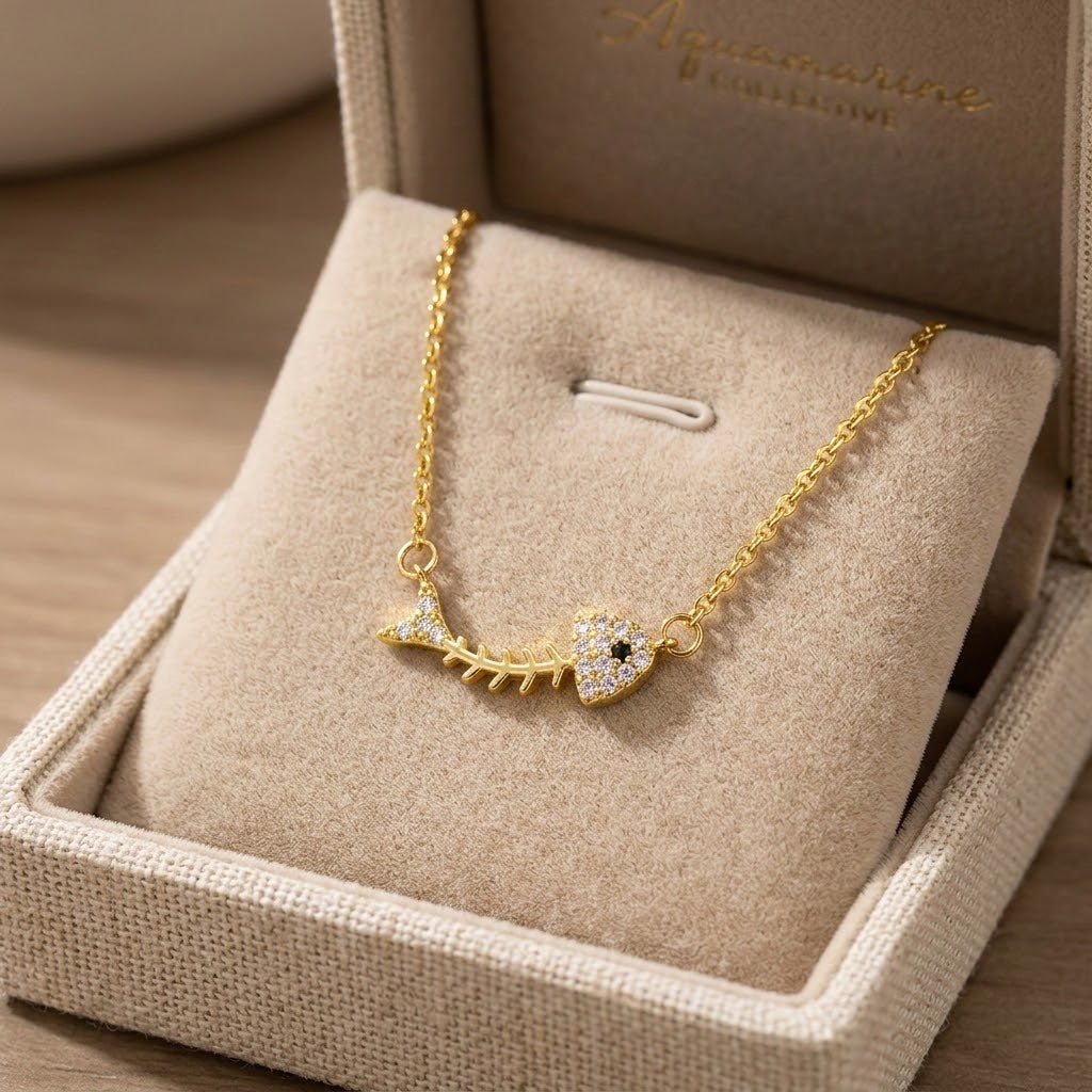 Gold-tone fishbone charm necklace with small crystal accents