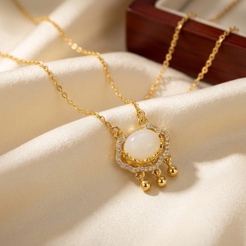 Gold-tone oval halo pendant necklace with sparkling bezel and three bead dangles