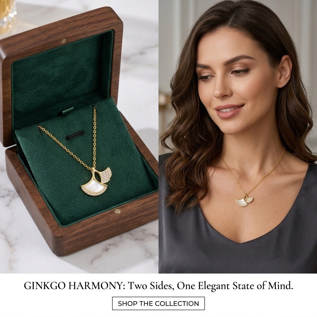 Gold ginkgo leaf pendant necklace with clear stones, worn on woman with dark V-neck