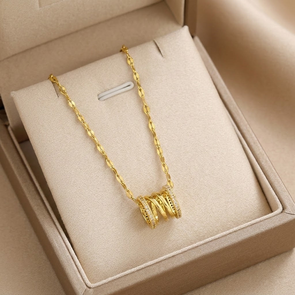 Gold-tone coil pendant necklace with faceted charm on link chain, in jewelry box