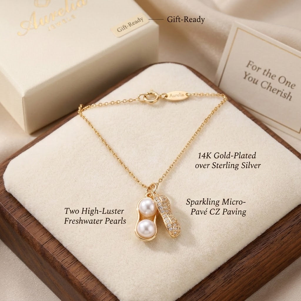 Gold-tone peanut-shaped pearl charm necklace with micro-pave crystal accents and pearls