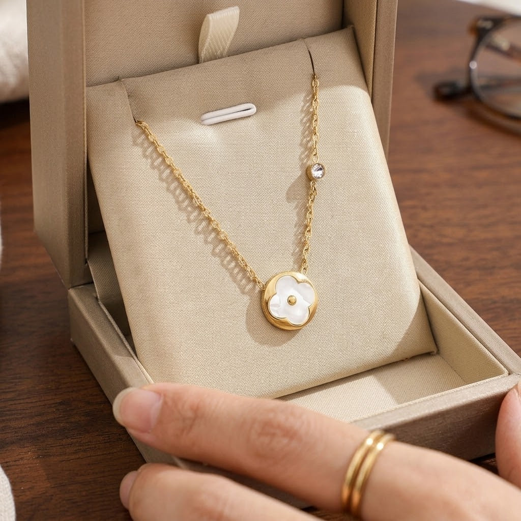 Gold-tone flower petal pendant necklace with round white inlay and short link chain