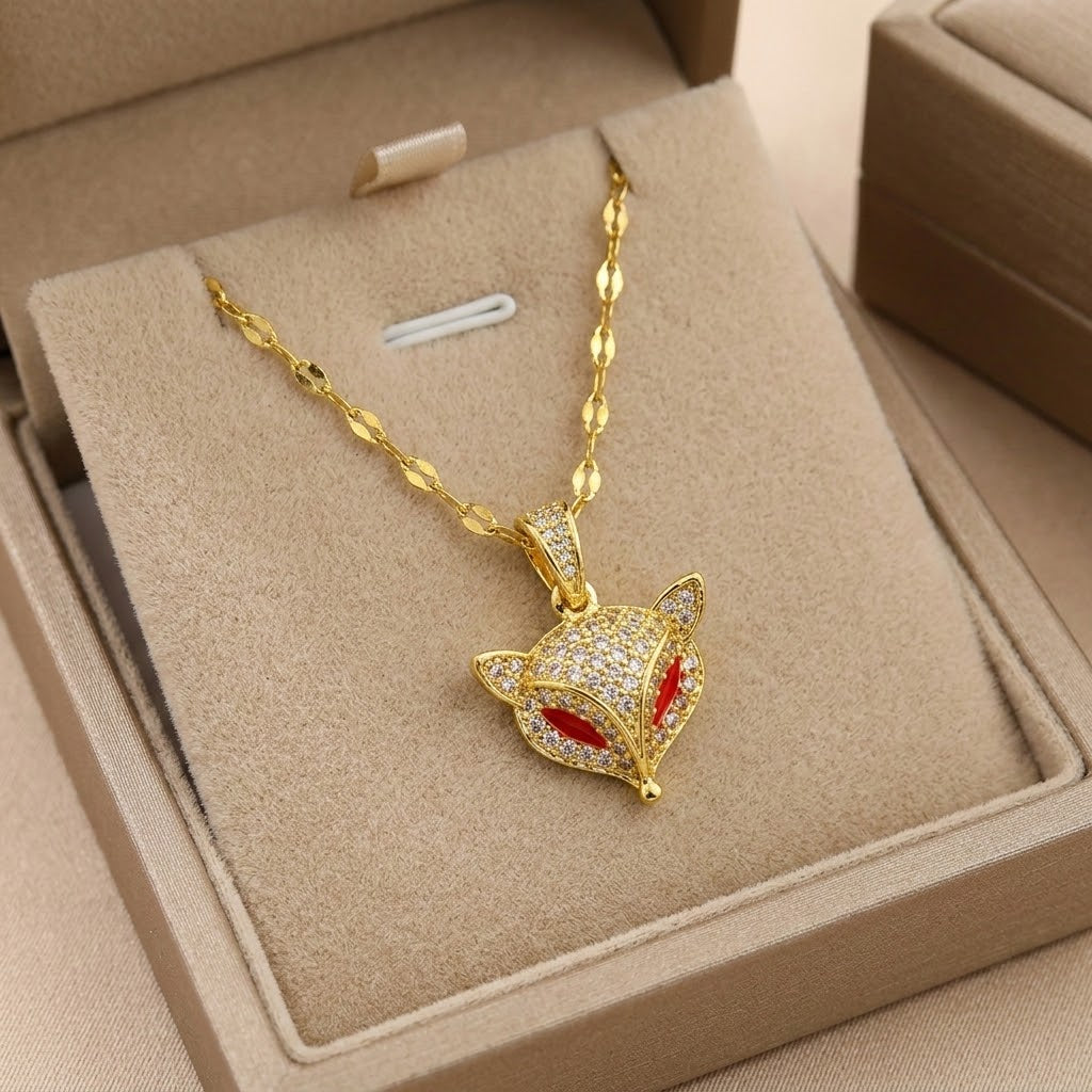 Gold-tone necklace with fox head charm, red enamel eyes and glittering crystal details