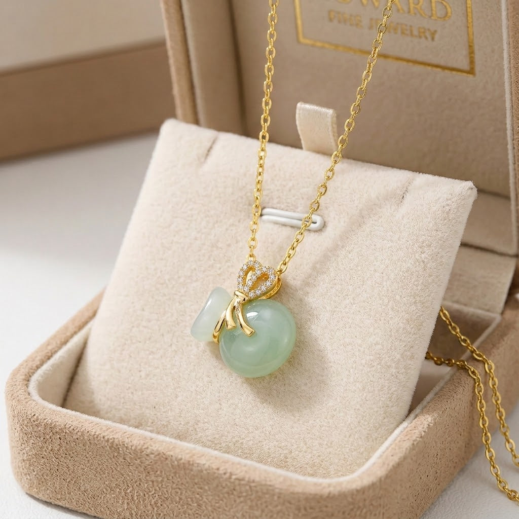 Gold-tone necklace with crown charm and light aqua bead pendant on fine chain