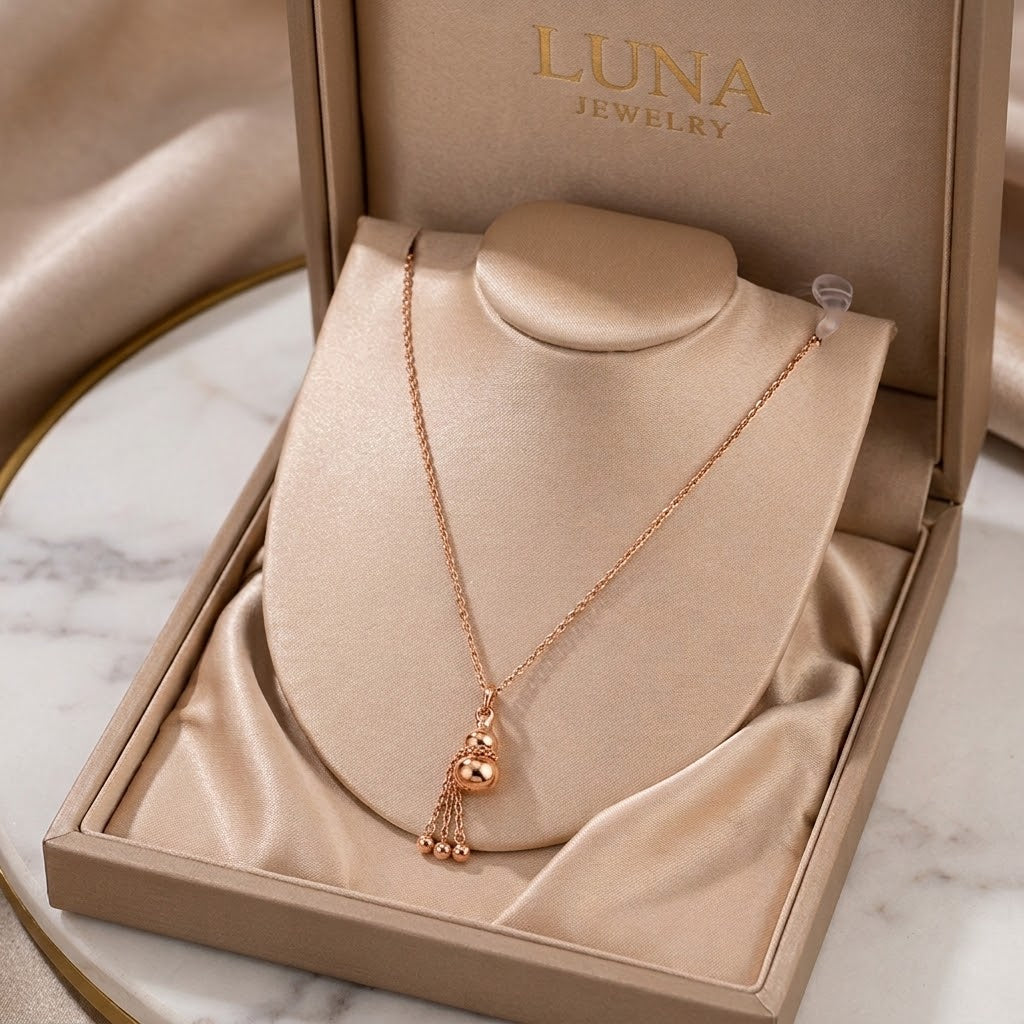 Rose gold mini gourd charm pendant necklace with small dangling charms on display stand