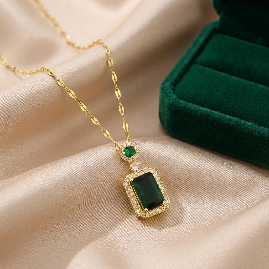 Gold-tone gemstone charm necklace with green square pendant and small round accents