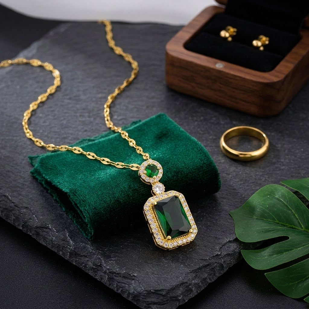 Gold-tone gemstone charm necklace with green square pendant and crystal halo details