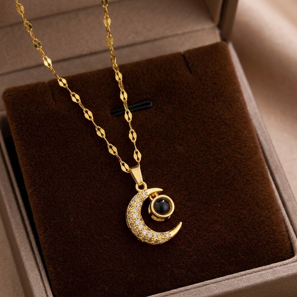 Gold moon charm pendant necklace with crescent pendant and dark round center eye