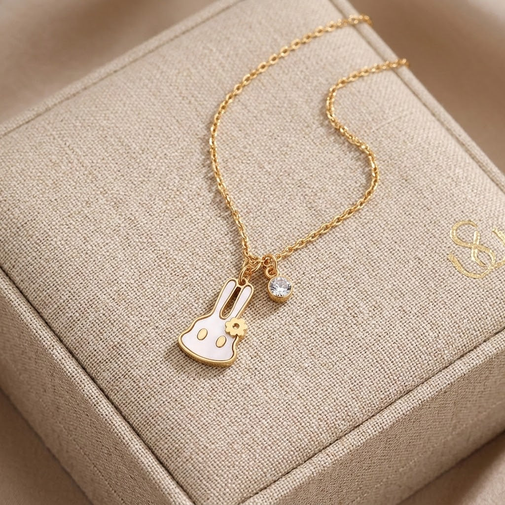 Gold-tone bunny pendant necklace with flower charm and small round rhinestone