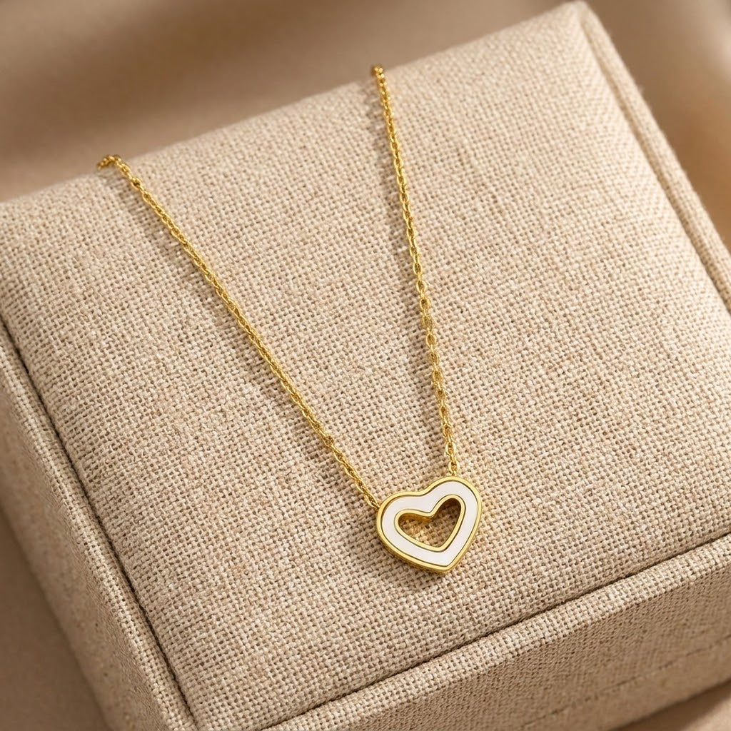 Gold-tone hollow heart pendant necklace with heart-shaped charm, angled view in box