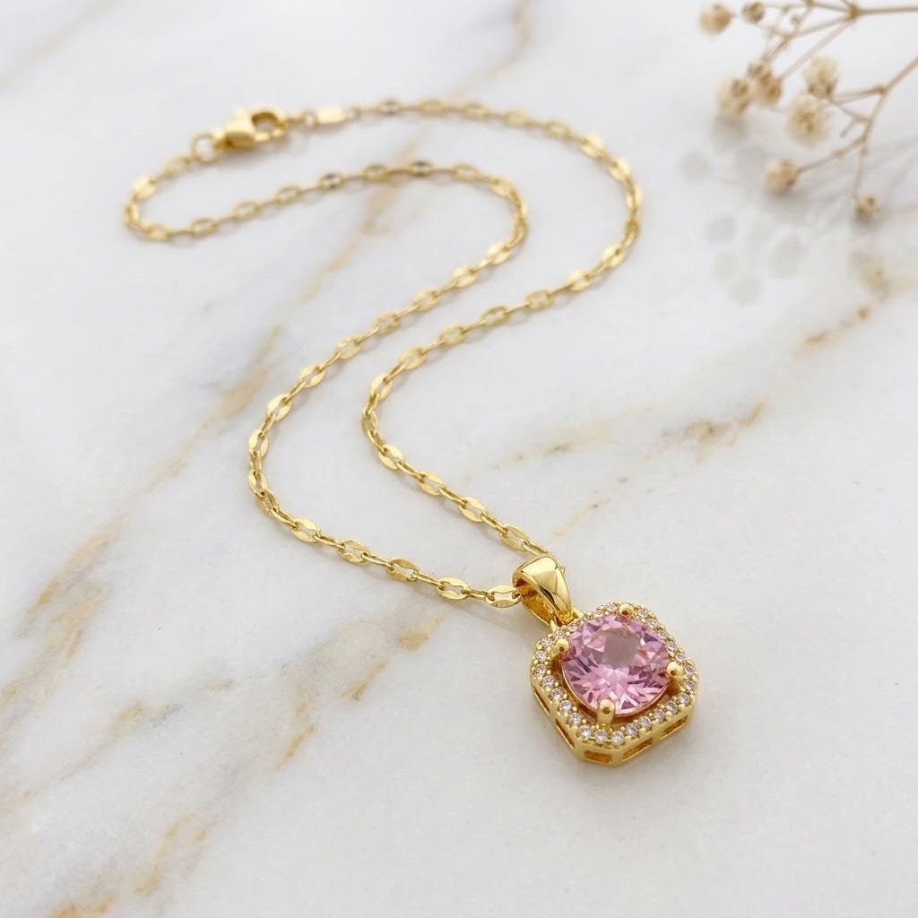 Gold pendant necklace featuring a pink round halo gemstone on chain