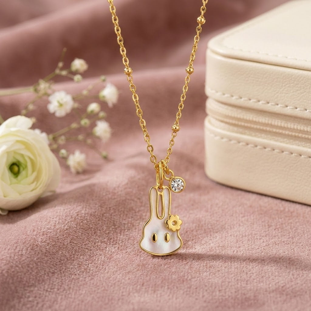 Gold-tone floral pendant necklace with bunny charm and round rhinestone detail