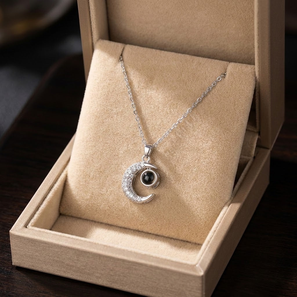 Silver crescent moon pendant necklace, round dark center on glitter edge