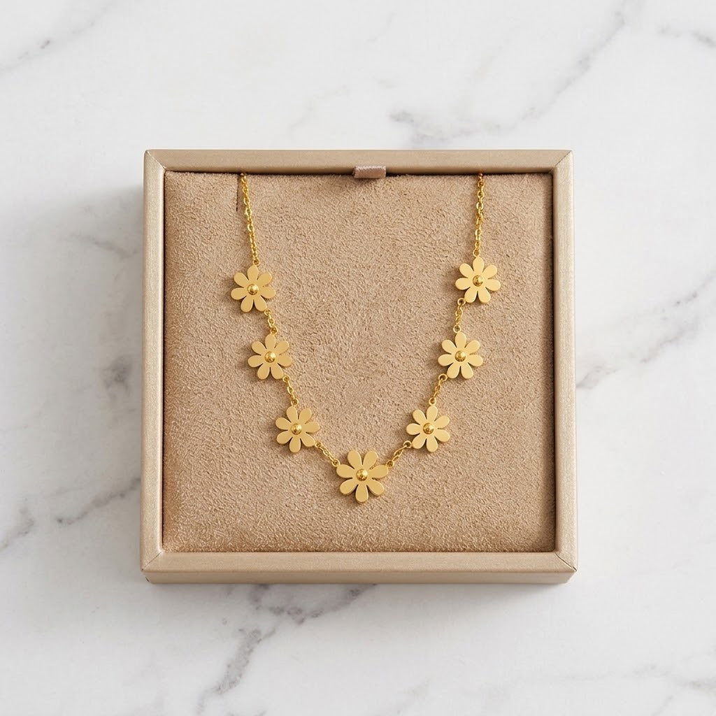 Gold wildflower charm necklace in box with five-petal flower pendant stations