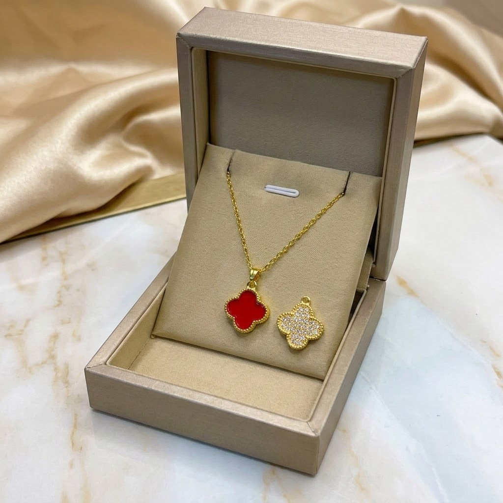 Floral pendant necklace in gold with red clover charm, shown in gift box