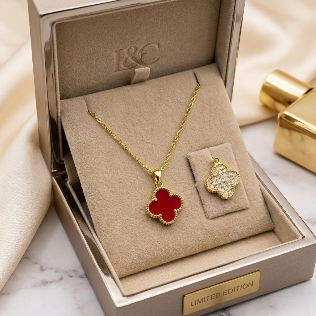 Gold floral pendant necklace with red clover charm, shown in a gift box